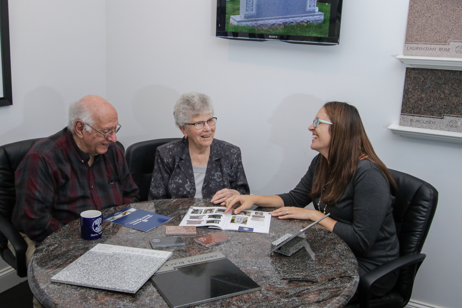 Elderly couple reviewing monument options with a Weaver Memorials rep