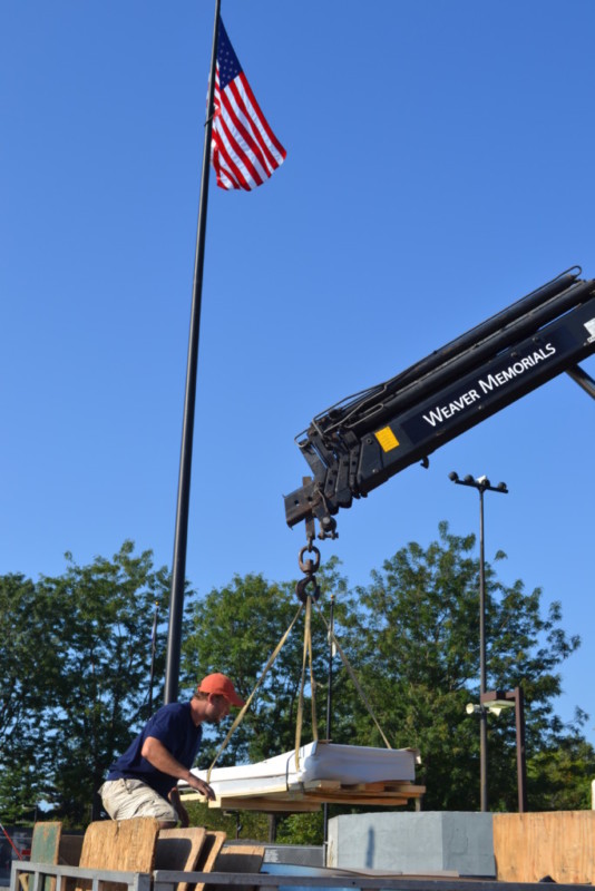 Stone slab being lifted off of a truck.